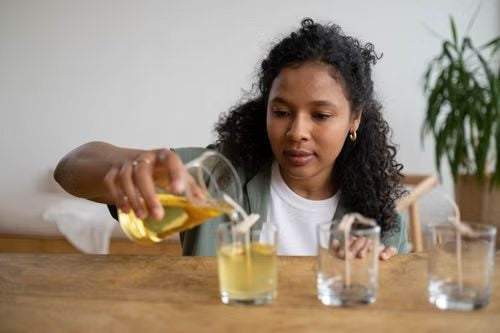 Mujer vertiendo cera en vasos para hacer velas
